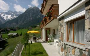 ein Haus mit einer Terrasse mit einem Tisch und einem Sonnenschirm in der Unterkunft Appart Saroja-Tannleger in Brand + 12 Fotos