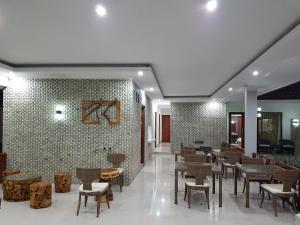 un restaurante con mesas y sillas y una pared de ladrillo en Villa Pine Tree, en Gili Trawangan