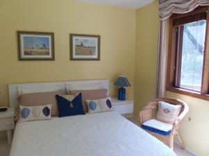 a bedroom with a bed and a chair and a window at End of the road B & B in Cranbrook