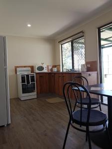 a kitchen with a table and chairs and a refrigerator at D'Aguilar Hotel Motel in DʼAguilar