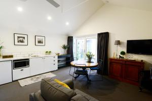 a living room with a table and a kitchen at Clement House in Benalla