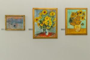 cuatro pinturas de un jarrón de girasoles en una pared en Art & Wine Studios and Apts en Lárnaca