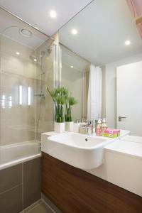 a bathroom with a tub, sink and mirror at Citadines Holborn - Covent Garden London in London