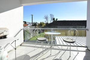 einen Balkon mit einem Tisch und 2 Hockern in der Unterkunft Carlton Villa 3 - Christchurch Holiday Homes in Christchurch