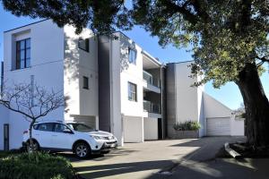 una casa bianca con una macchina parcheggiata di fronte di Carlton Villa 3 - Christchurch Holiday Homes a Christchurch