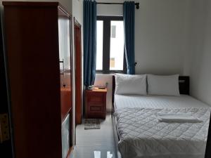 a small bedroom with a bed and a window at Nice Hotel in Da Nang