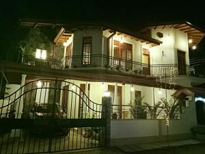 a large white house with a gate at night at White House Ella in Ella