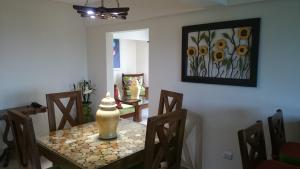 Las Flores的住宿－Luxury Karla Apartments，一间带桌椅和绘画的用餐室