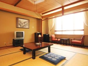 a living room with a coffee table and a tv at Shiga Kogen Lodge in Yamanouchi
