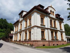 a large white building with a tower on top at Apartmány U Davídků in Cerny Dul