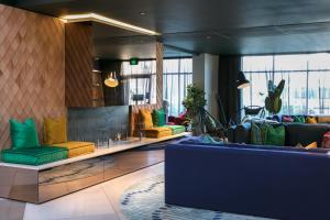 a lobby with yellow and green furniture in a building at Naumi Auckland Airport Hotel in Auckland