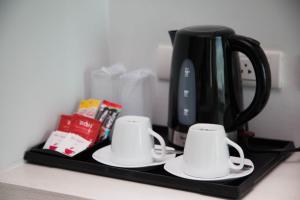 a coffee cup sitting on top of a counter next to a microwave at The Bloc Hotel - SHA Extra Plus in Patong Beach