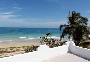 a view of the beach from the balcony of a house at Casa Los Delfines in Puerto Villamil