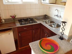 a kitchen with a stove and a sink at Pineapple Guest House Entebbe in Entebbe