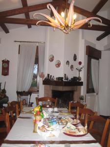 una sala da pranzo con tavolo e lampadario pendente di B&B Oasi di Venezia a Campalto