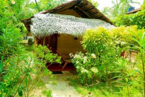 a small hut with a thatched roof in a forest at Natural Cabanas in Tangalle