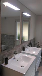ein Badezimmer mit einem weißen Waschbecken und einem Spiegel in der Unterkunft Cà di Noni in Gordevio
