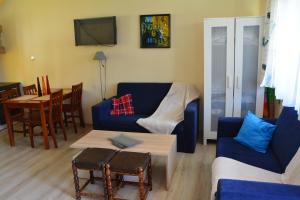 sala de estar con sofá azul y mesa en Fortuna en Rewal
