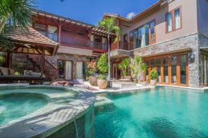 a swimming pool in front of a house at Villa Martine - Fantastic 5BR Villa - Perfect Location in Seminyak in Seminyak