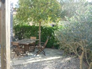 エーグ・モルトにあるAigues-Mortes villa prés des rempartsの木の下のパティオ(テーブル、椅子付)