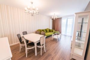 a living room with a table and a green couch at UBA Accommodation in Cluj-Napoca