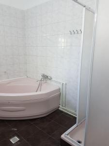 a white bathroom with a tub and a shower at Pensiunea Geostar 2 in Curtea de Argeş +49 photos