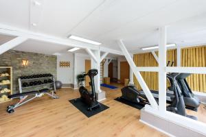 a gym with treadmills and exercise equipment in a building at Landhaus Zu den Rothen Forellen in Ilsenburg