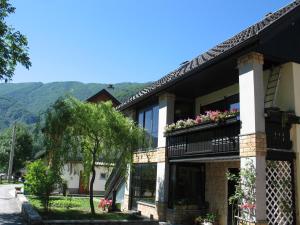 a building with flowers on the balconies with mountains in the background at Apartment Mars in Bovec