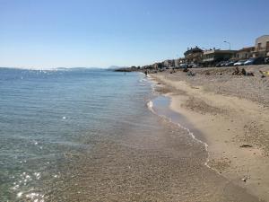 a beach with people on it and the water at Beach Appartament in Marina di Montemarciano