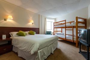 a bedroom with two bunk beds and a television at The Grand Burstin Hotel in Folkestone