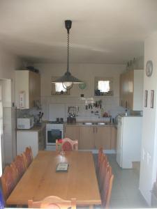 a large kitchen with a wooden table and chairs at Gyula-tanya Vendégház in Csongrád