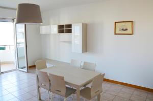 una sala da pranzo con tavolo e sedie bianchi di Elegance ad Alba Adriatica