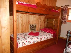 ラ・サルにあるBaita nel verde - cir 0122のベッドルーム1室(木製の二段ベッド1組、赤い枕付)