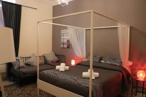 sypialnia z łóżkiem z baldachimem i krzesłem w obiekcie Happy Stay Guesthouse w Rzymie