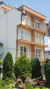 een gebouw met balkons en bomen ervoor bij Vila Andrra in Struga