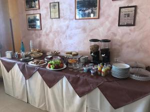 einen Tisch mit Lebensmitteln und Teller mit Lebensmitteln darauf in der Unterkunft Rosy And Roby in Gasponi