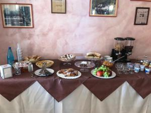 einen Tisch mit Speisen und Desserts auf dem Tisch in der Unterkunft Rosy And Roby in Gasponi