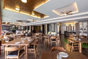 un ristorante con tavoli e sedie in legno e un divano di The Regent Phuket Bangtao Beach a Bang Tao Beach