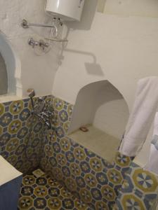 a bathroom with a toilet with a tile floor at Labboo'z Café and Lodge in Maheshwar