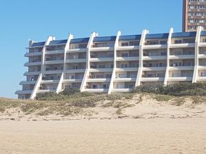 un gran edificio en la playa junto a la arena en L'Escalier, en Amanzimtoti