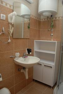 a bathroom with a sink and a mirror and a toilet at Apartments Mitic in Kopaonik