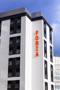 un edificio bianco con un cartello rosso dell'hotel di HOTEL FORZA HAKATA-GUCHI a Fukuoka