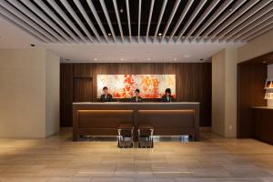 un vestíbulo con 2 personas sentado en la recepción en HOTEL FORZA HAKATA-GUCHI en Fukuoka