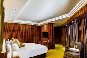 1 dormitorio con 1 cama, 1 silla y TV en Moty Hotel en Melaka