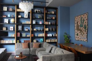 sala de estar con sofá y estante para libros en c-hotels Joy, en Florencia