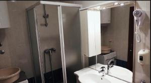 Un baño con lavabo y ducha y un lavabo. en Apartments Villa Marta, en Opatija