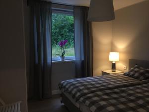 a bedroom with a bed and a window with a potted plant at Landvetter House in Landvetter