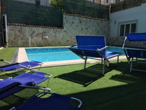 two blue chairs sitting next to a swimming pool at Hotel San Berardo in Pescina