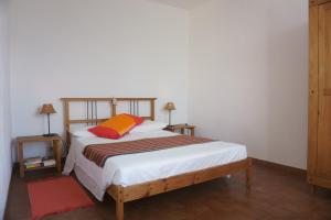 ネーにあるFarmhouse B&B Castagnola 64のベッドルーム1室(オレンジ色の枕とテーブル2台付)