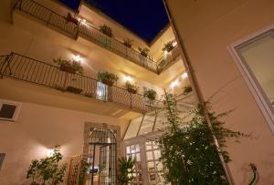 a building with a balcony with potted plants on it at Cas'E Charming House in Caserta
